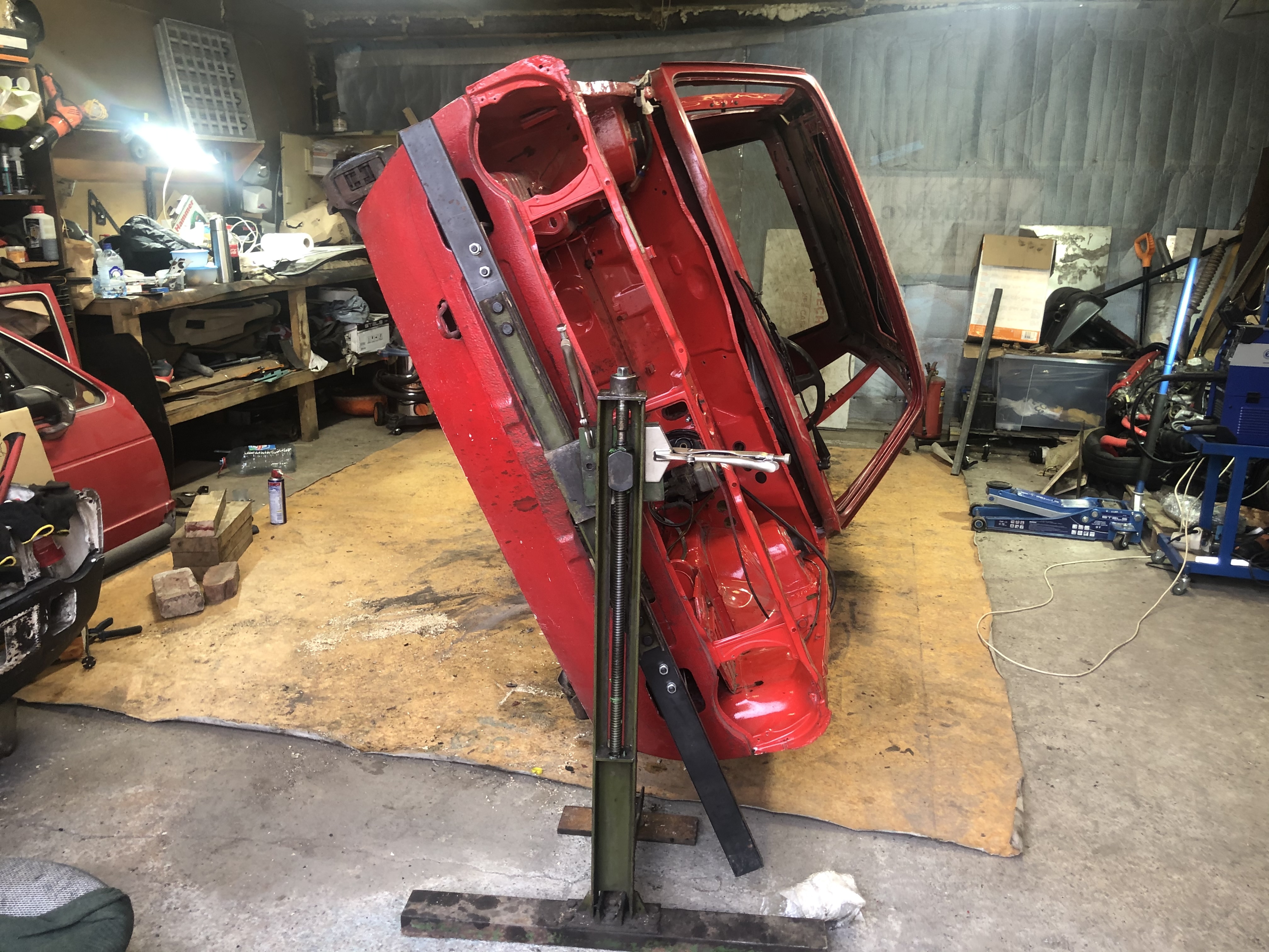 Rote Karosserie eines klassischen Autos während der Restauration in einer Werkstatt
